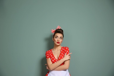 Photo of Portrait of funny young housewife on color background