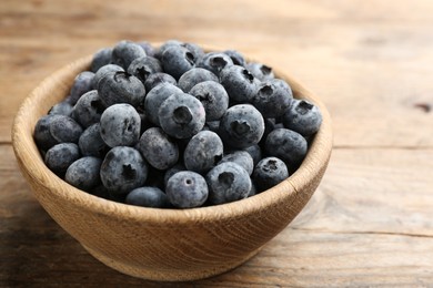 Photo of Tasty frozen blueberries on wooden table, closeup