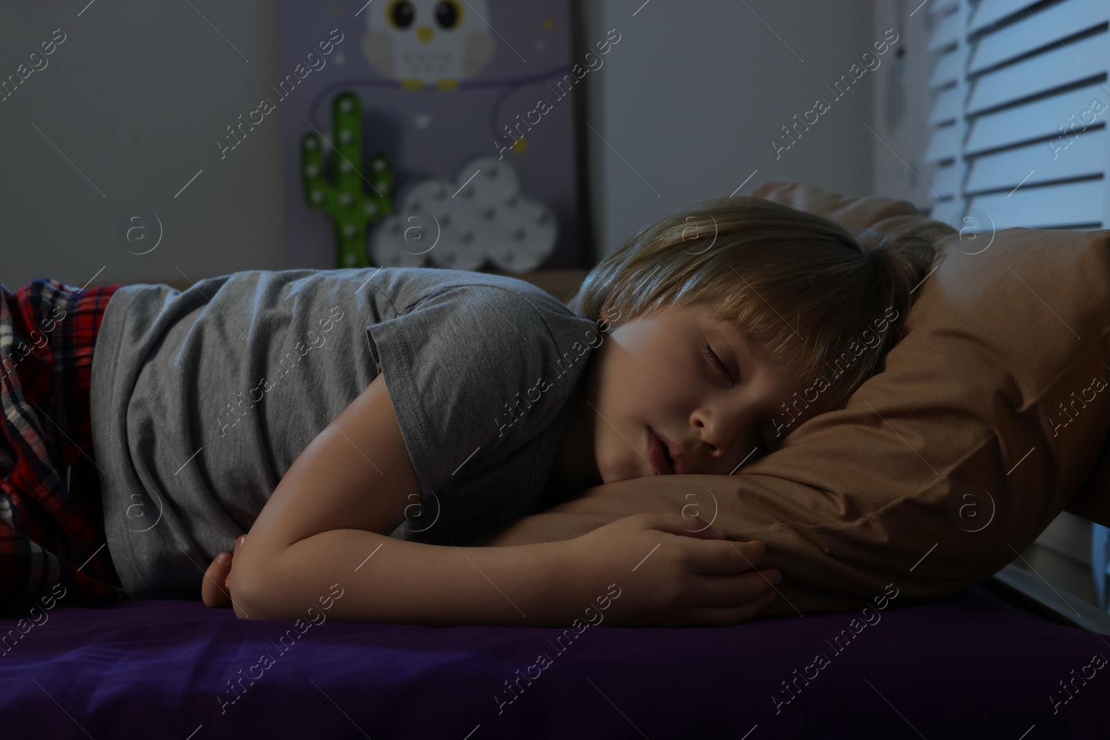 Photo of Little boy snoring while sleeping in bed at night