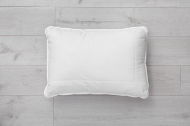 Photo of Clean soft bed pillow on wooden background, top view