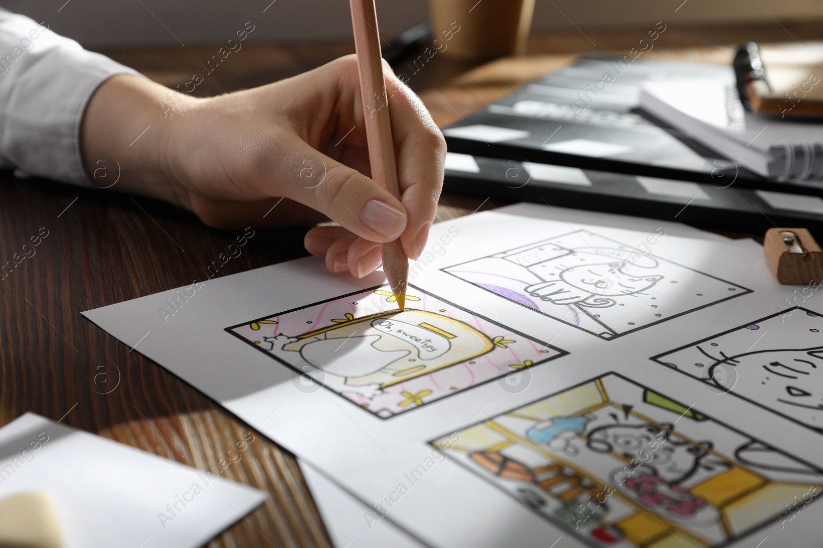 Photo of Woman drawing cartoon sketch at workplace, closeup. Pre-production process