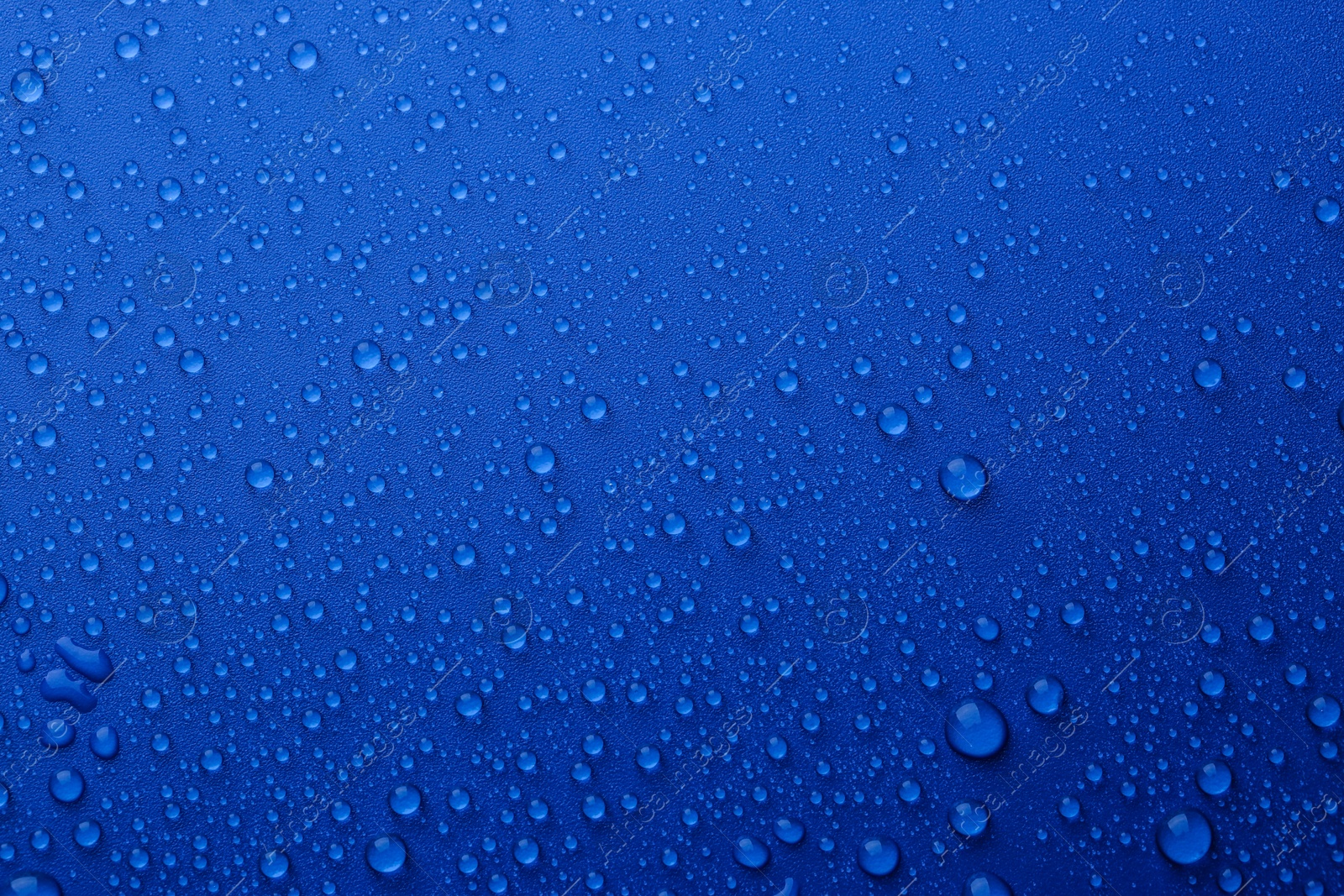 Photo of Water drops on blue background, top view