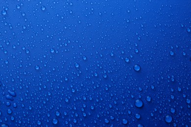 Photo of Water drops on blue background, top view