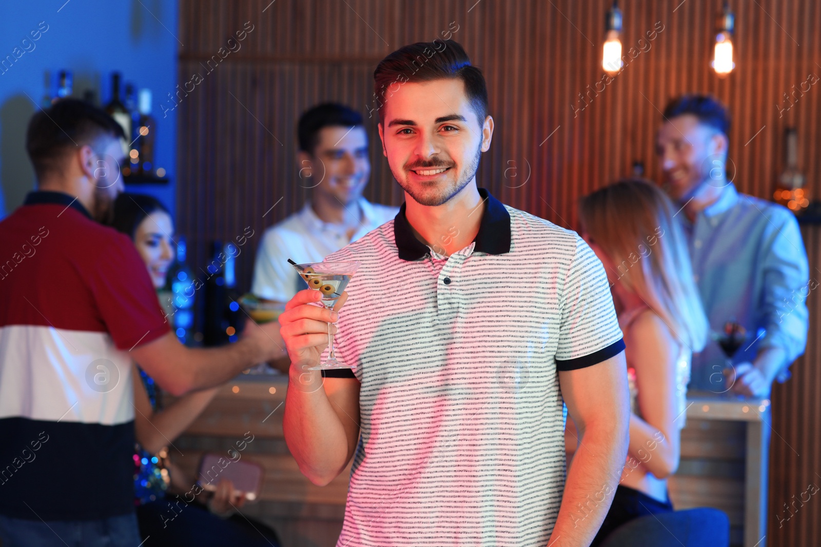 Photo of Young man with glass of martini cocktail at party