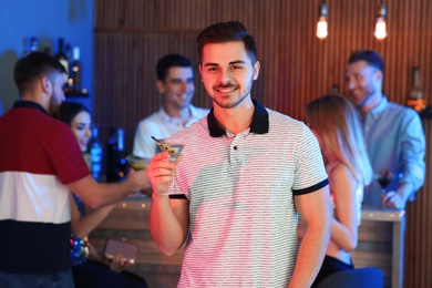 Photo of Young man with glass of martini cocktail at party