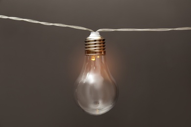 Lamp with light bulb on grey background