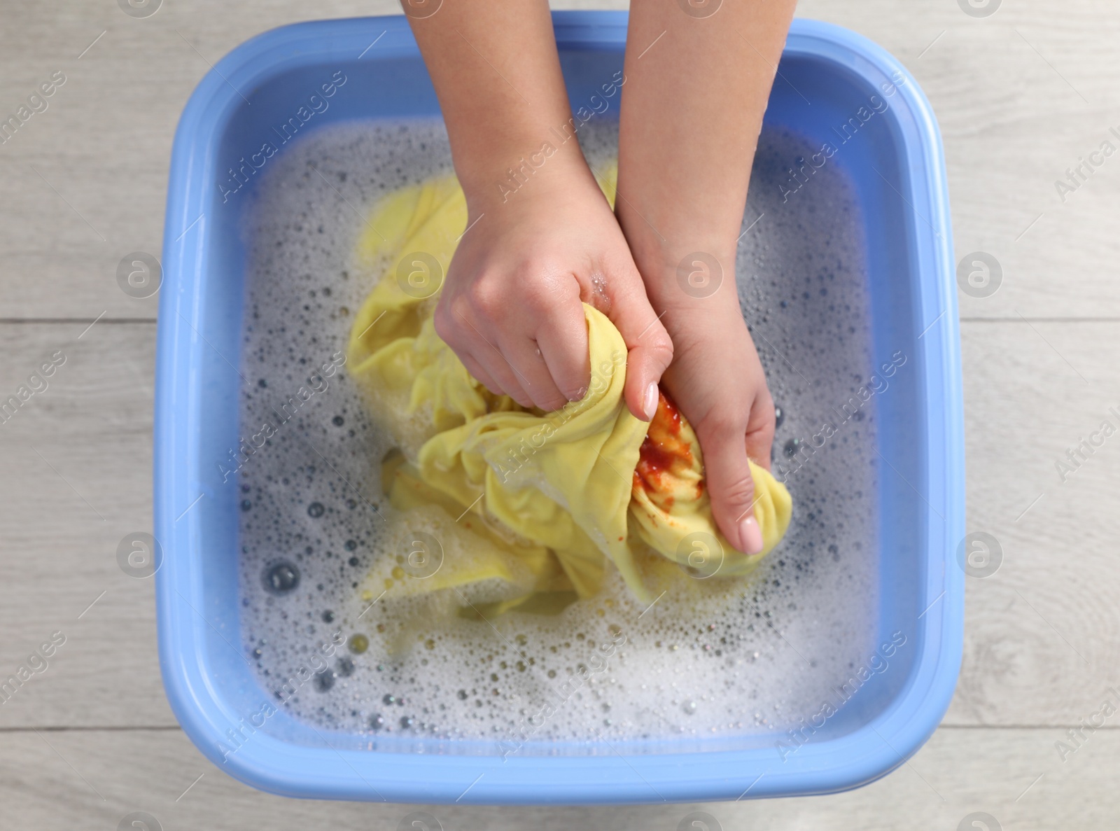 Photo of Woman washing garment with stain, top view