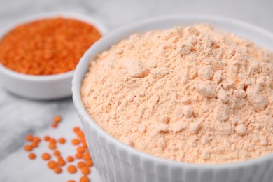 Photo of Lentil flour and seeds on white marble table, closeup