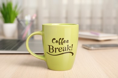 Mug with inscription Coffee Break on wooden table in office