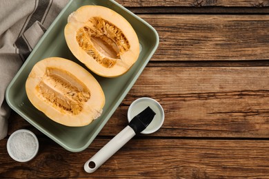 Photo of Halves of fresh spaghetti squash in baking dish on wooden table, flat lay with space for text. Cooking at home