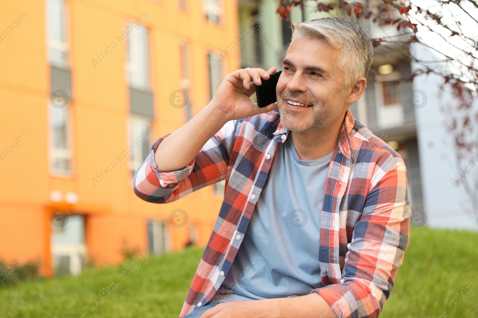 Photo of Handsome mature man talking on phone in park