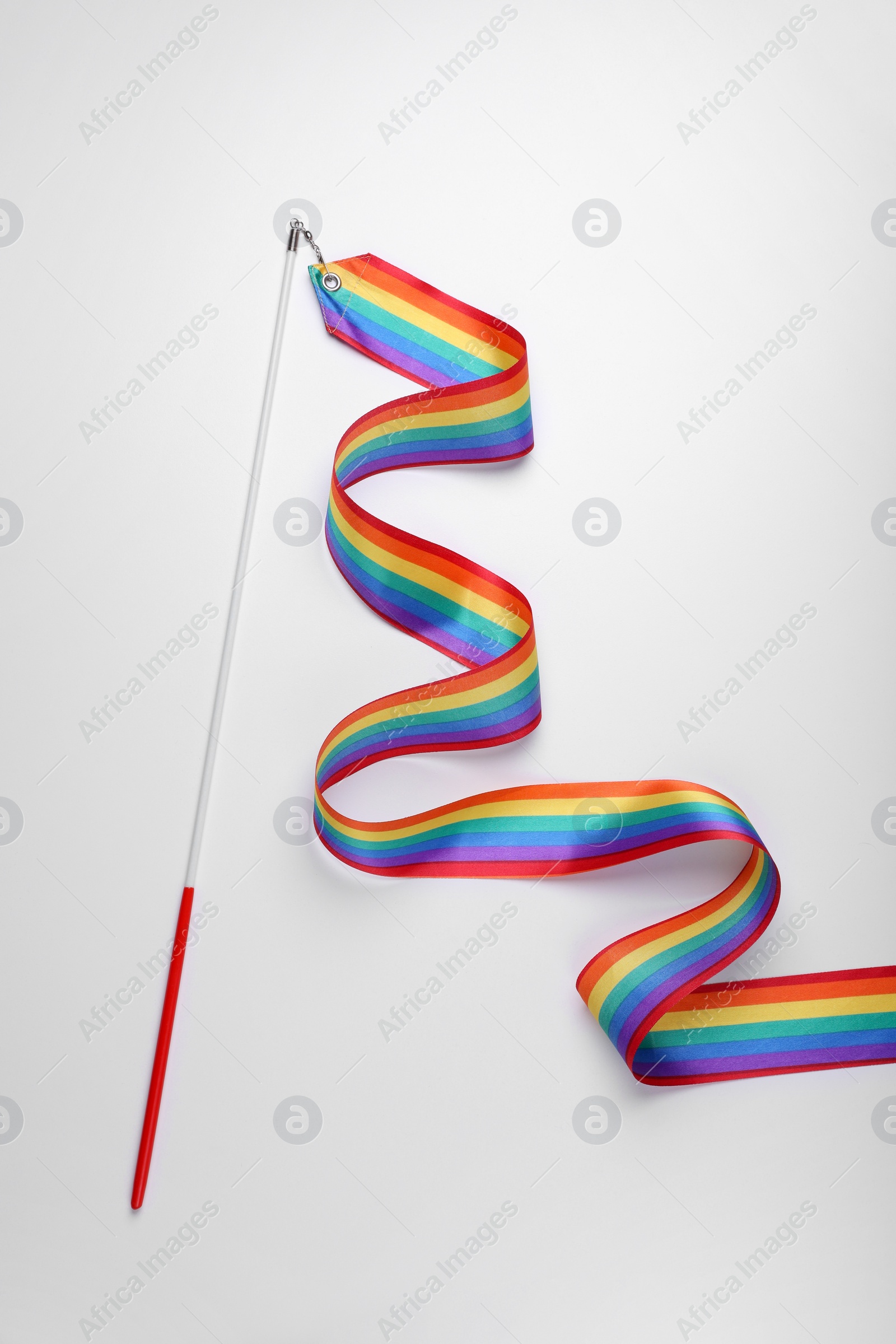 Photo of Rainbow gymnastics ribbon on white background, top view. LGBT pride