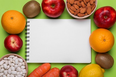 Photo of Notebook,, fresh fruits and vegetables on light green background, flat lay. Low glycemic index diet