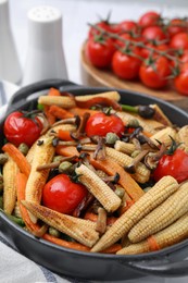 Photo of Tasty roasted baby corn with tomatoes, capers and mushrooms on table, closeup