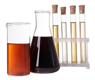 Photo of Different laboratory glassware with brown liquids on white background