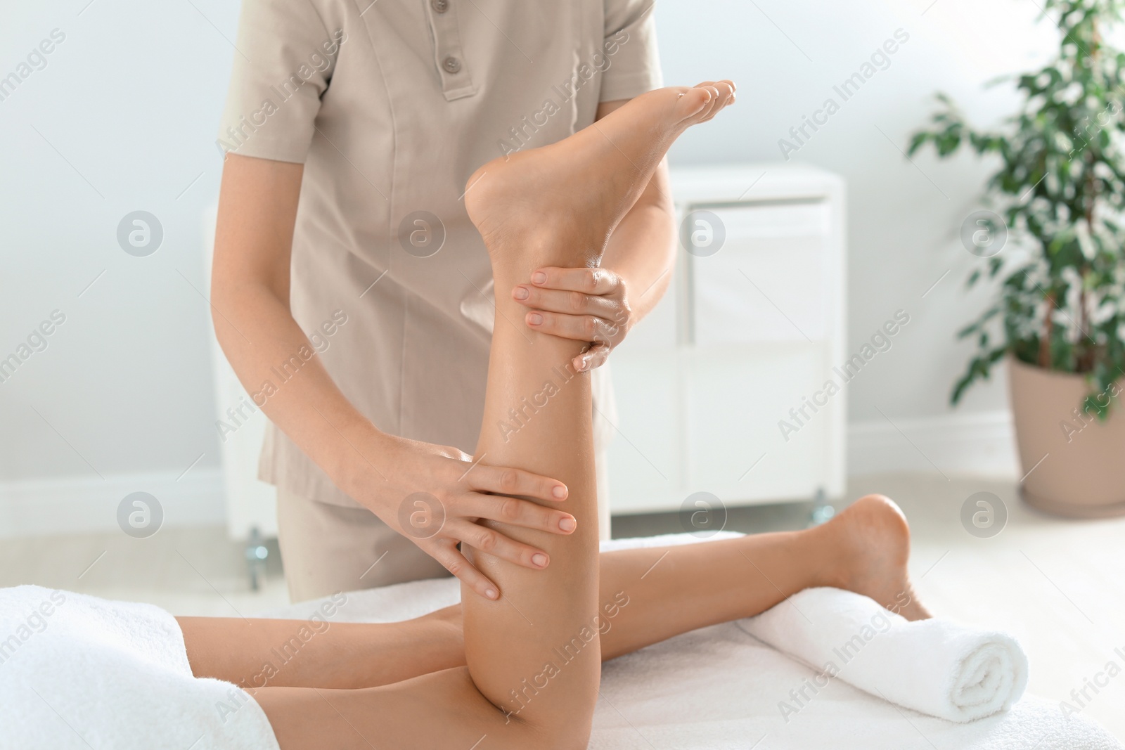 Woman receiving leg massage in wellness center Photo of Woman receiving leg massage in wellness center