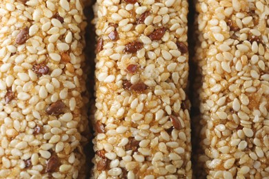 Photo of Tasty sesame seed bars as background, top view
