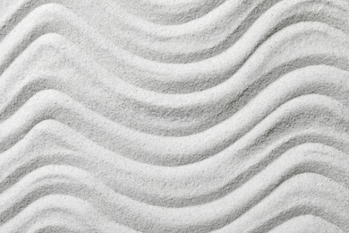 Photo of Zen garden pattern on sand as background, top view. Meditation and harmony