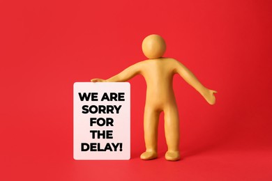 Image of Plasticine human figure with note We Are Sorry For The Delay on red background