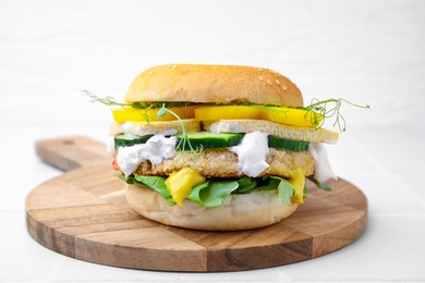 Photo of Tasty vegan burger with vegetables, sauce and patty on white background