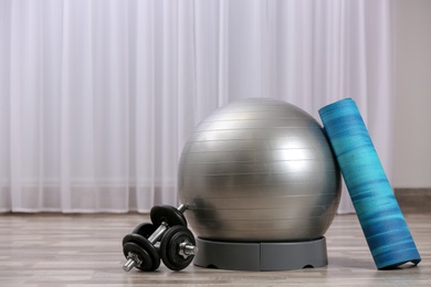 Photo of Set of fitness equipment on floor indoors. Space for text