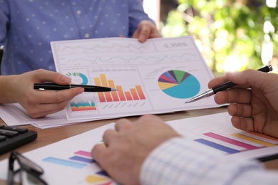 Photo of Business people working with charts and graphs at table in office, closeup. Investment analysis