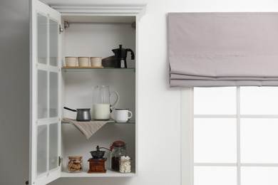 Photo of Vintage coffee grinder and other appliances on shelving unit in kitchen