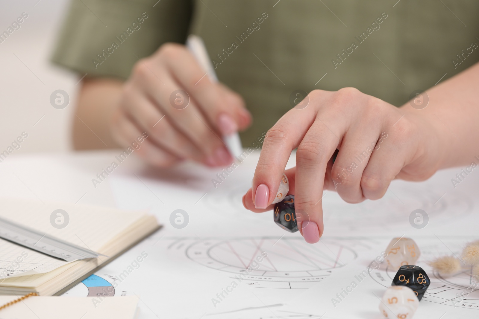 Photo of Astrologer using dices for fate forecast at table, closeup. Fortune telling
