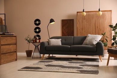 Photo of Stylish living room interior with comfortable dark sofa