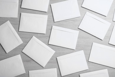 Photo of Many white paper envelopes on wooden table, flat lay