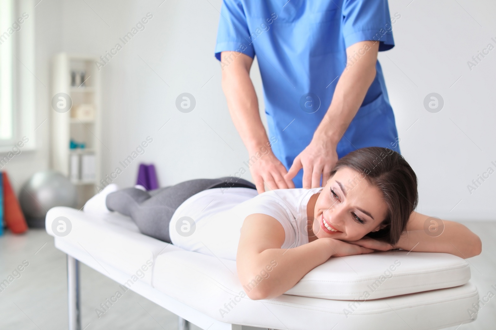 Photo of Physiotherapist working with female patient in clinic