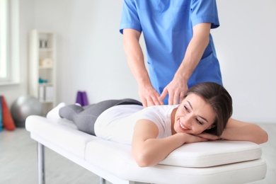 Photo of Physiotherapist working with female patient in clinic