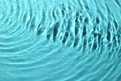 Image of Rippled surface of clear water on light blue background, closeup