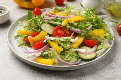 Photo of Tasty fresh vegetarian salad on grey table, closeup