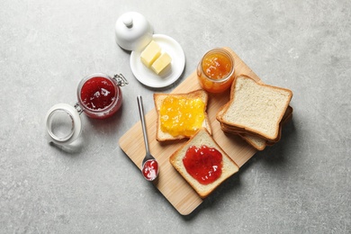 Photo of Flat lay composition with toast bread, jam and butter on grey background