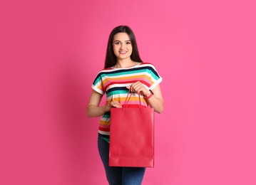 Photo of Beautiful young woman with stylish blank paper bag against color background
