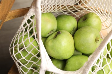 Photo of Fresh green apples in net bag, closeup