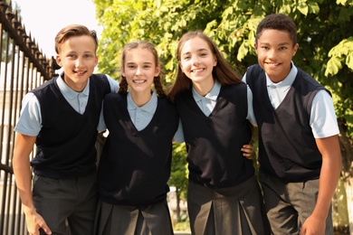 Photo of Teenage students in stylish school uniform outdoors