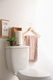 Photo of Decor elements, necessities and toilet bowl near white wall. Bathroom interior