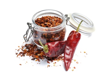 Photo of Jar with crushed chili pepper and pods on white background