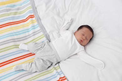 Photo of Cute newborn baby sleeping on soft bed, top view