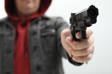 Photo of Dangerous criminal with gun indoors, selective focus. Armed robbery