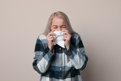 Photo of Sick mature woman on beige background. Dangerous virus