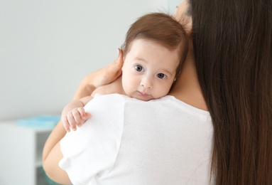 Photo of Woman holding her baby at home, closeup