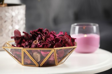 Photo of Aromatic potpourri of dried flowers in bowl on white table indoors