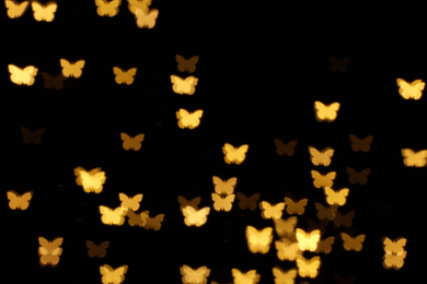 Photo of Blurred view of butterfly shaped lights on black background. Bokeh effect