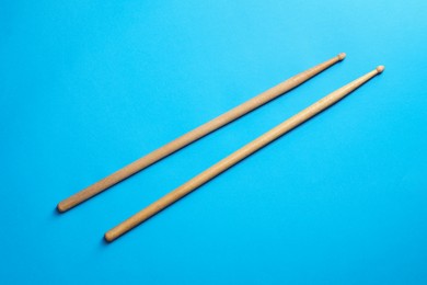 Photo of Two wooden drum sticks on light blue background