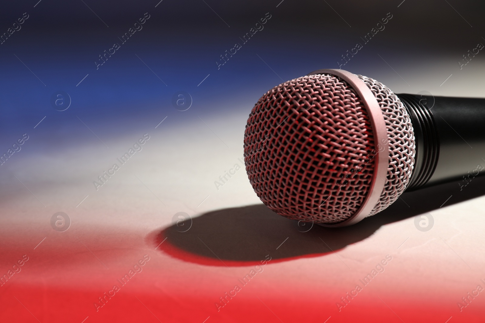 Photo of Modern microphone on color background, closeup. Space for text