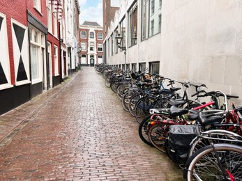 Many parked bicycles near building on city street