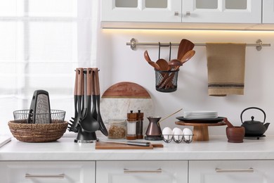 Set of different utensils and dishes on countertop in kitchen